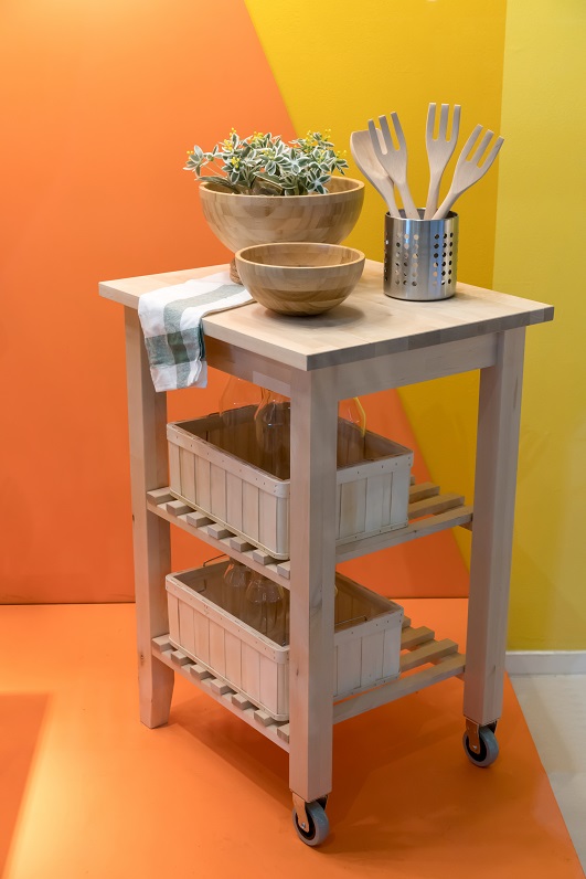 Wooden island kitchen cart for home design and decoration against yellow wall.