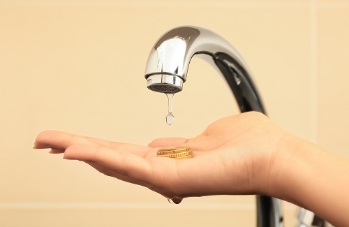 Woman holding coins under metal tap, closeup. Water saving concept