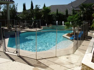 Architecture-Awesome-Cement-Deck-With-Glass-Fence-In-Marvelous-Swimming-Pool-Design-Beautiful-Above-Ground-Pool-Deck-Ideas-With-Cool-And-Beautiful-Design-Swimming-Pool-With-Fence-Surrounding-Decor