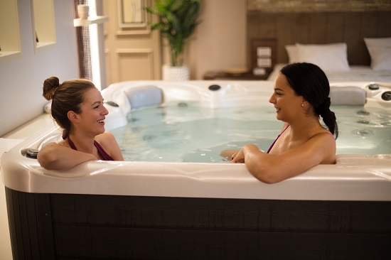 Chatting and enjoying. Two young woman in hot tub.
