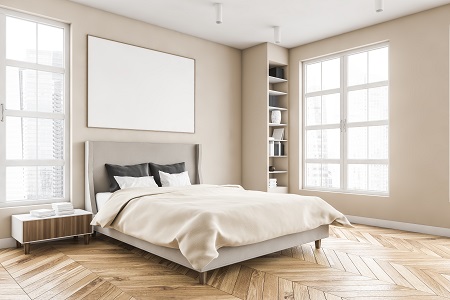 Wooden living room with mockup frame over the bed with linens on parquet floor, side view. Light brown minimalist bedroom with shelves and books. Windows with city view, no people 3D rendering