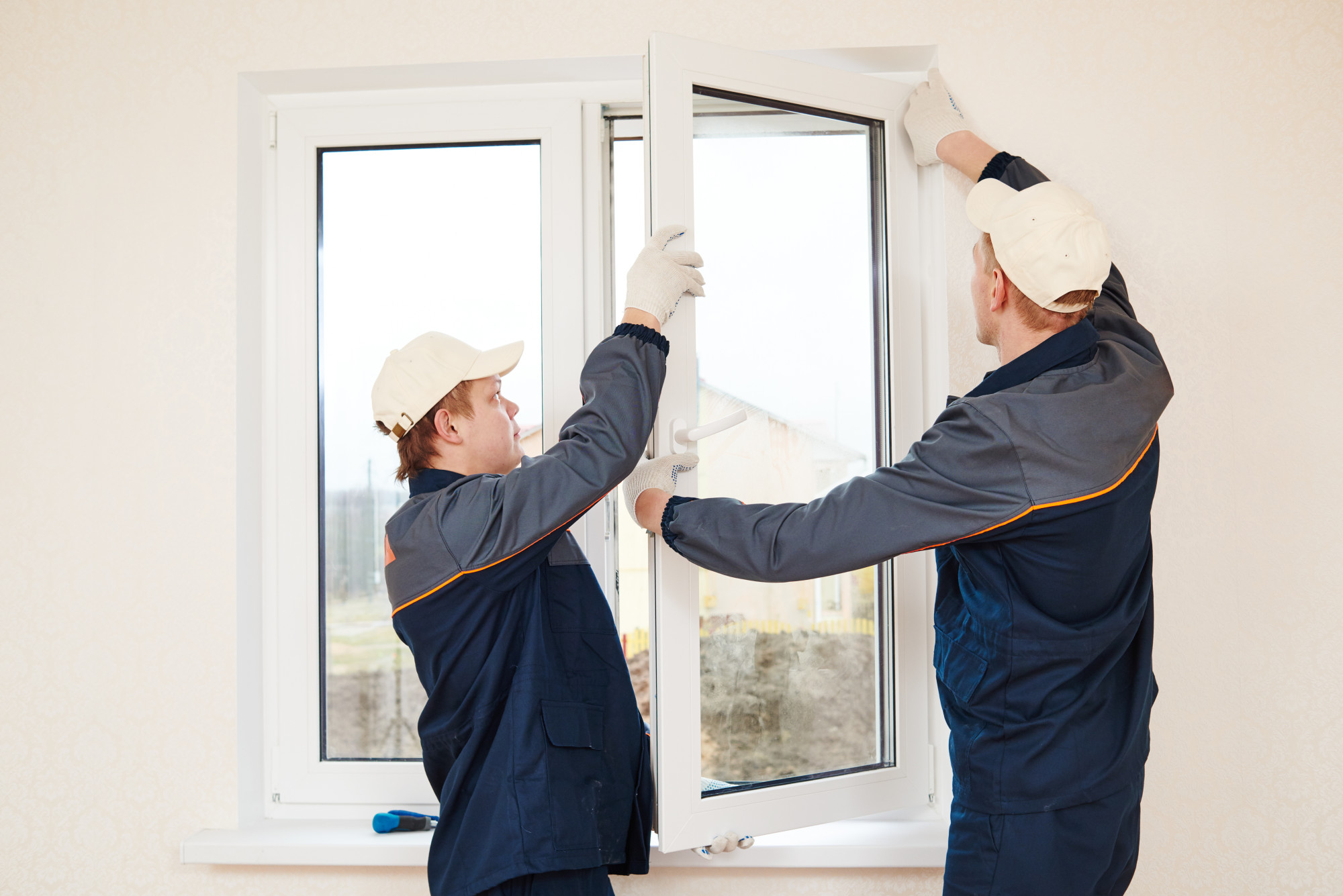 construction workers glaziers installing glass window indoor